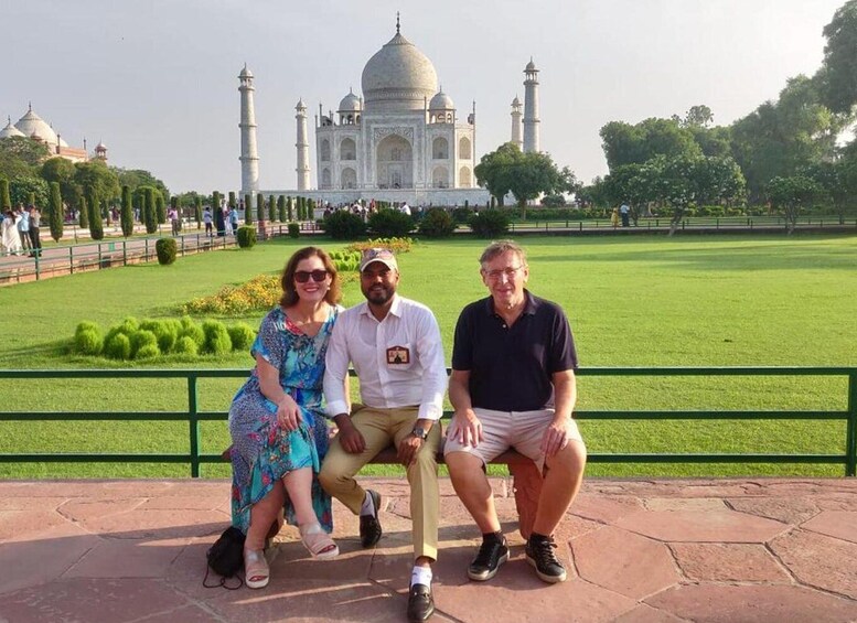 Three people posing in front of the Taj Mahal. 1