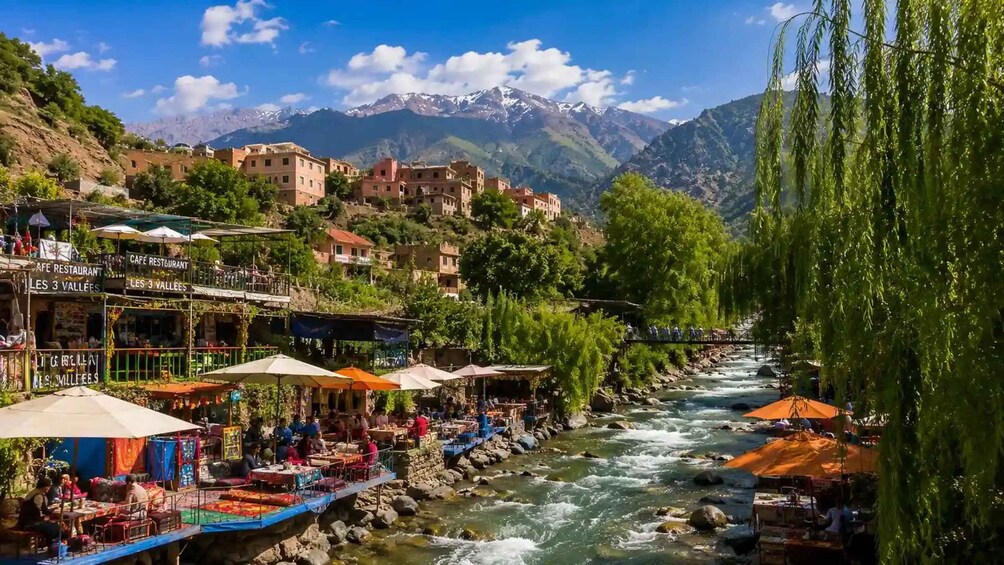 A riverside town with buildings, a river, and mountains in the background. 5