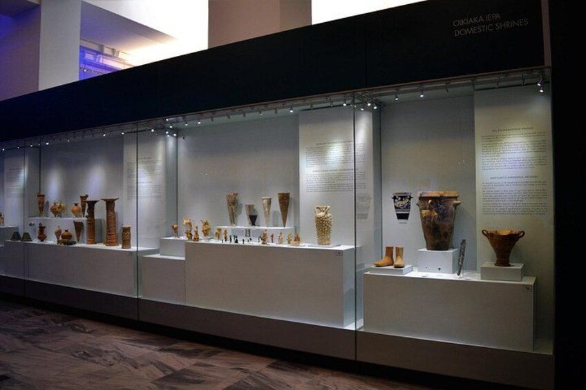 Una exhibición en museo con vitrinas de vidrio que contienen diversa cerámica antigua y artefactos. 5