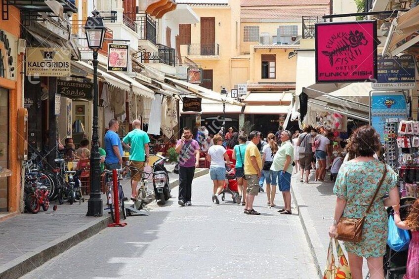 Una calle concurrida con peatones, bicicletas y tiendas. 2