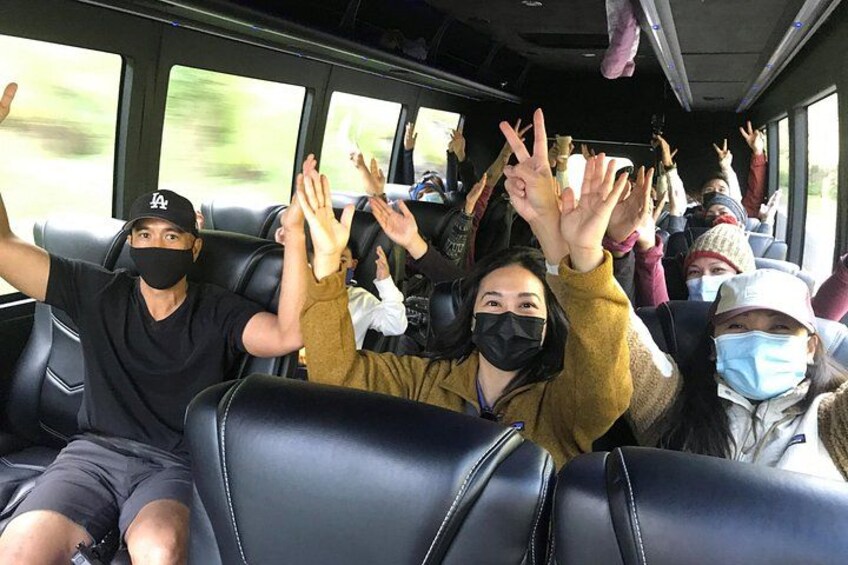 People on a bus with their hands raised. 3