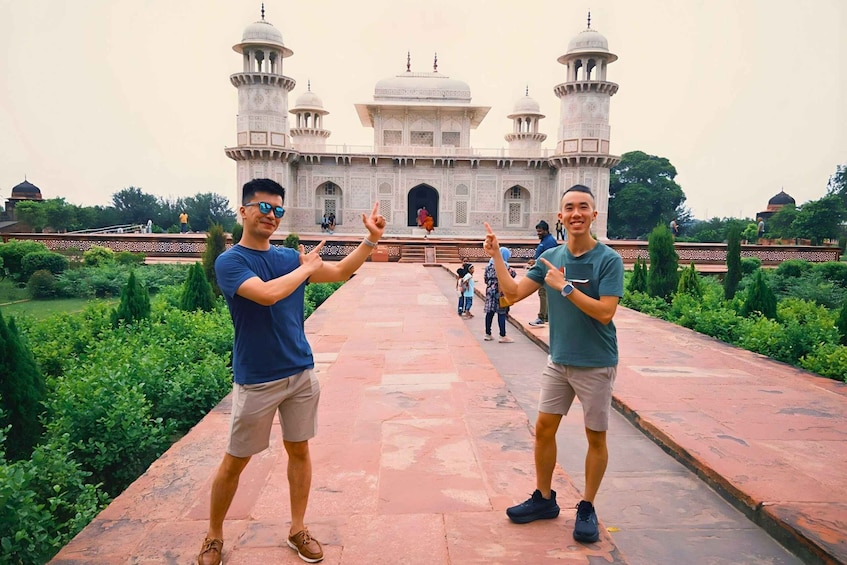 Two people posing in front of a large, ornate building with domes and minarets. 4
