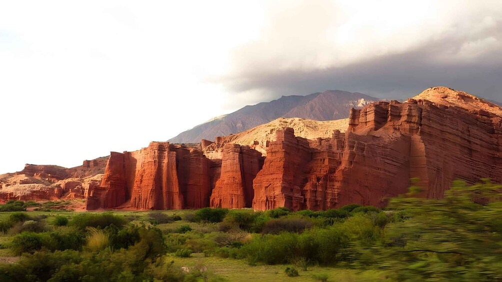 A red rock formation with a mountain in the background. 5