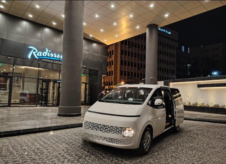 A white car parked in front of a building with a sign that reads 'Radisson.' 5