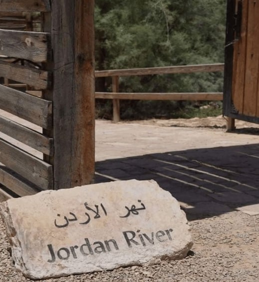 A stone with 'Jordan River' written on it, placed on a gravel surface. 1
