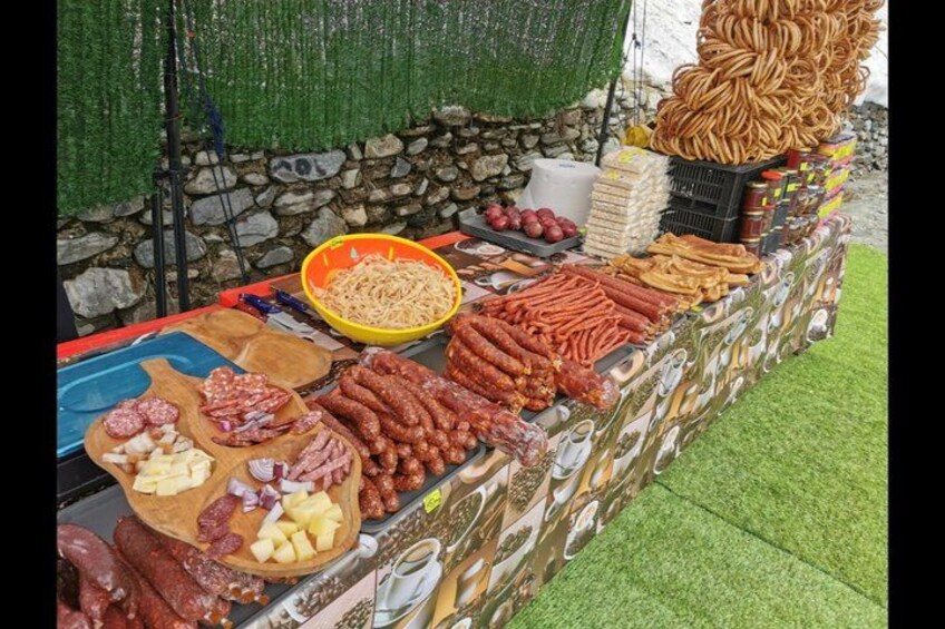 A variety of sausages and meats displayed on a table outdoors. 2