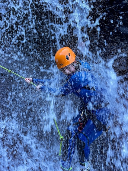 A person rappelling down a waterfall. 2