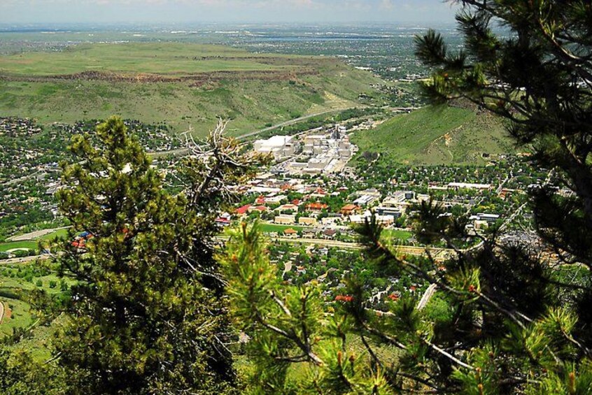 A town nestled in a valley with a prominent building in the center, surrounded by greenery and hills. 2