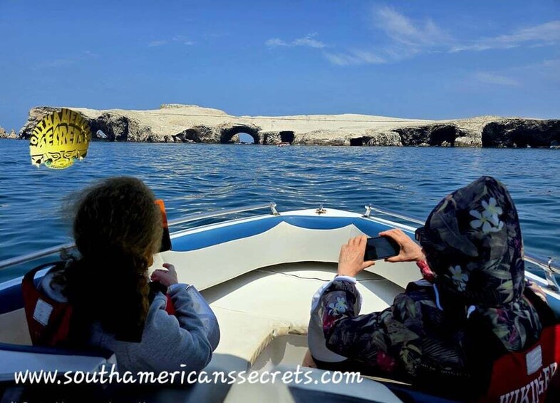 A boat on water with rocky cliffs in the background. 1