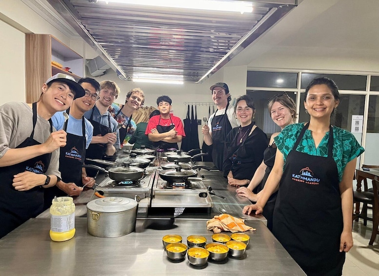 A group of people in a kitchen with cooking equipment and pots. 5