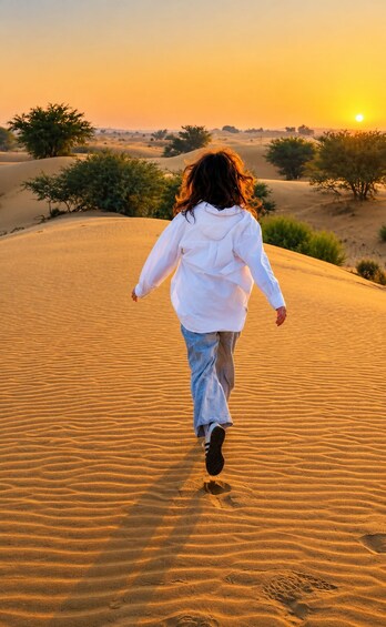A person walking on a sandy dune during sunset. 2