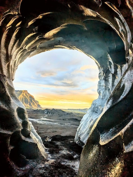 Una cueva de hielo con vistas a un paisaje montañoso. 5