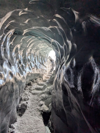 An ice cave with a narrow passage and ice formations. 4