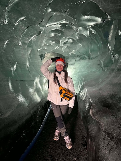 A person inside an ice cave with ice formations. 2