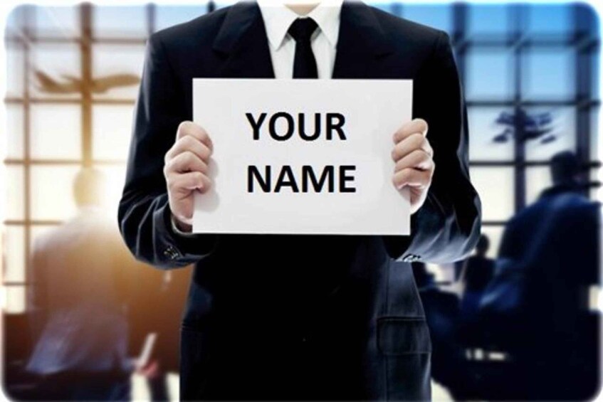 A person in a suit holding a sign with "YOUR NAME" written on it. 2