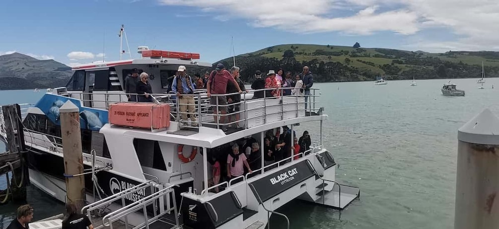 A ferry with passengers, a lifebuoy, and a sign reading "BLACK CAT EXPLORATION". 5