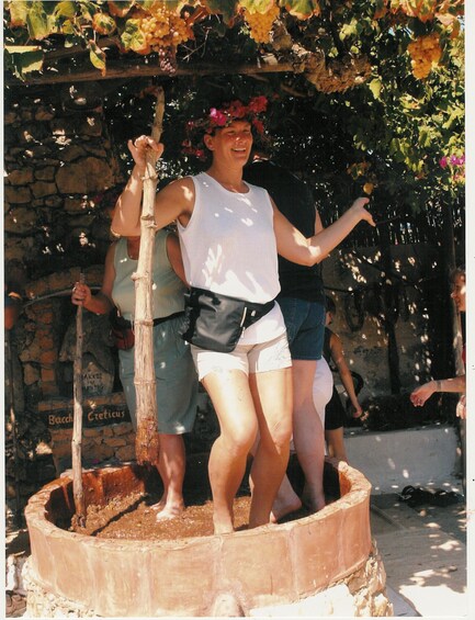 A person standing on a circular wooden platform with a tree in the background. 1