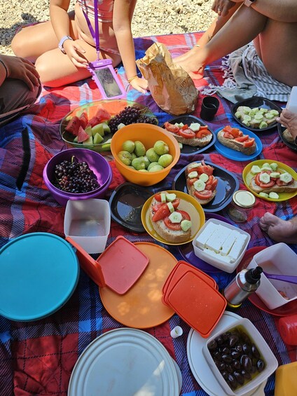 A picnic with various food items on a blanket. 3