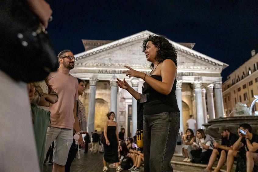 Une personne fait des gestes devant un bâtiment classique, doté de colonnes et portant l’inscription « MAGGIORE ». 5