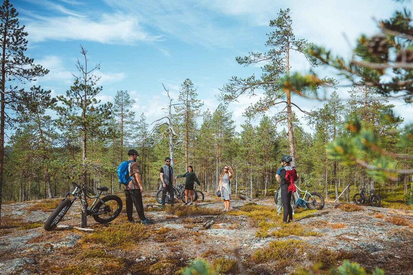 A group of people in a forest with bicycles and a mountain bike. 2