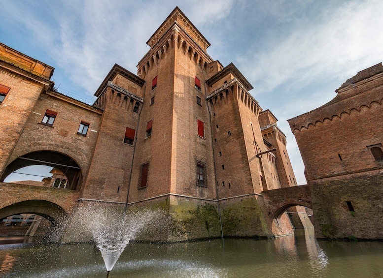 A historic brick building with arched windows and a central tower. 1