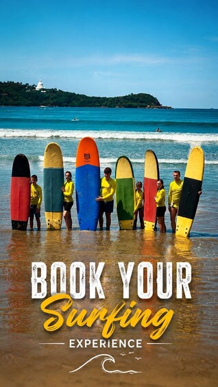 A group of people holding surfboards on a beach with a clear sky and a lighthouse in the background. 5
