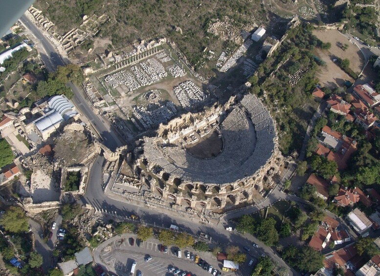 An ancient amphitheater surrounded by modern buildings and roads. 3
