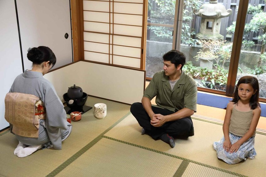A traditional Japanese room with tatami flooring, a shoji screen, and a view of a garden through the window. 2