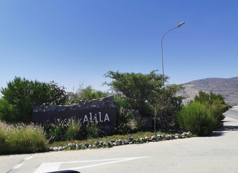 A road sign for Alila with a clear blue sky and a mountain in the background. 3