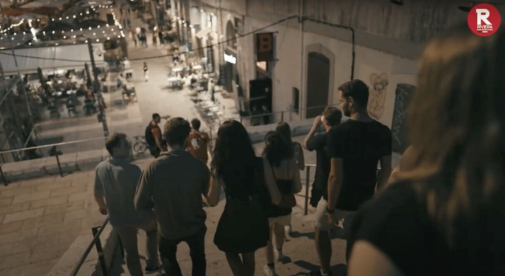 A group of people walking on a street at night. 3