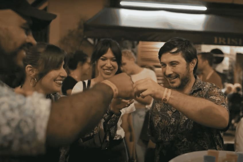 A group of people in a social setting, possibly a restaurant or bar, with a focus on their interaction. 2