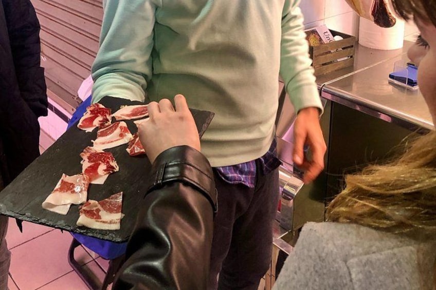 Una persona sosteniendo una bandeja con carne cortada. 1