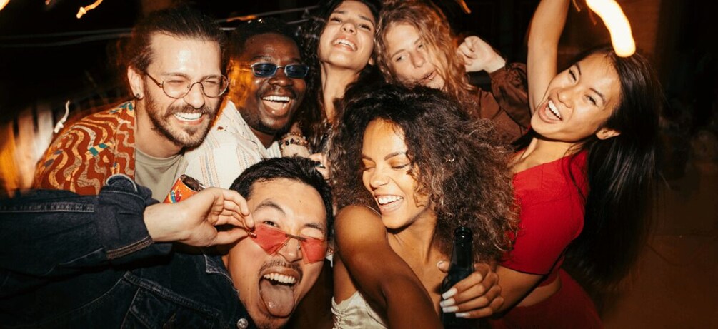 A group of people at a social event, some holding drinks. 2