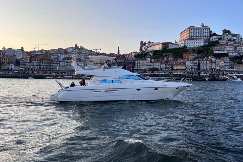 Un yate blanco sobre aguas tranquilas, con un paisaje urbano al fondo. 4