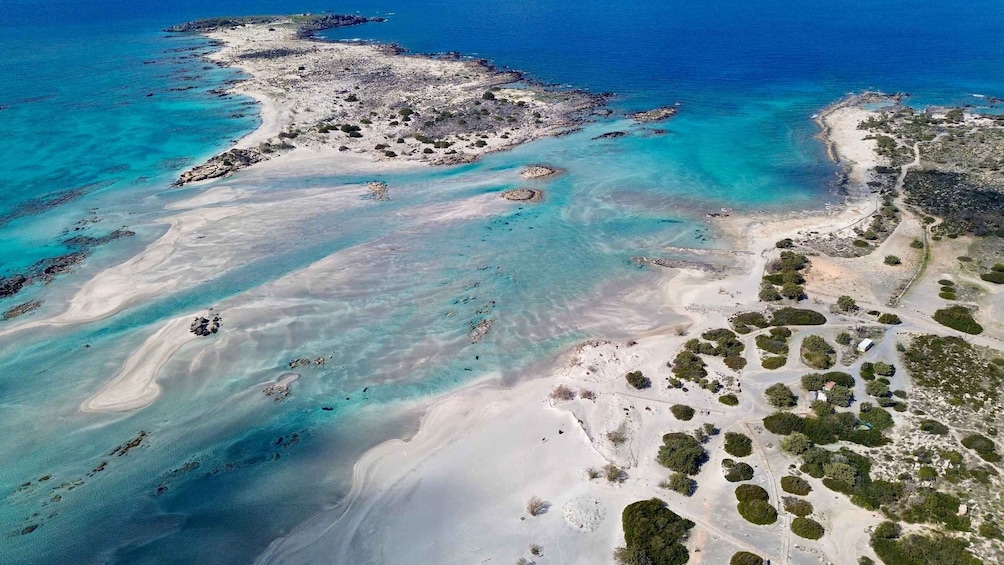 Vue aérienne d’une zone côtière avec des eaux turquoise limpides, des plages de sable et une végétation clairsemée. 5