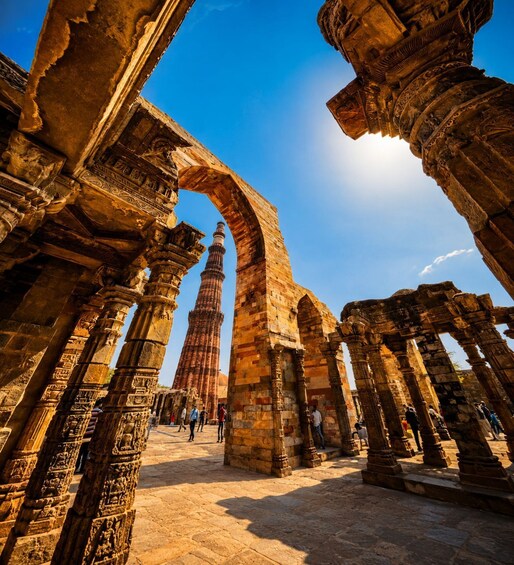 Ancient stone columns and an archway leading to a tall structure. 4