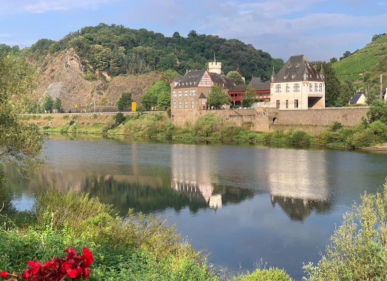 A calm river with a castle and surrounding greenery. 3