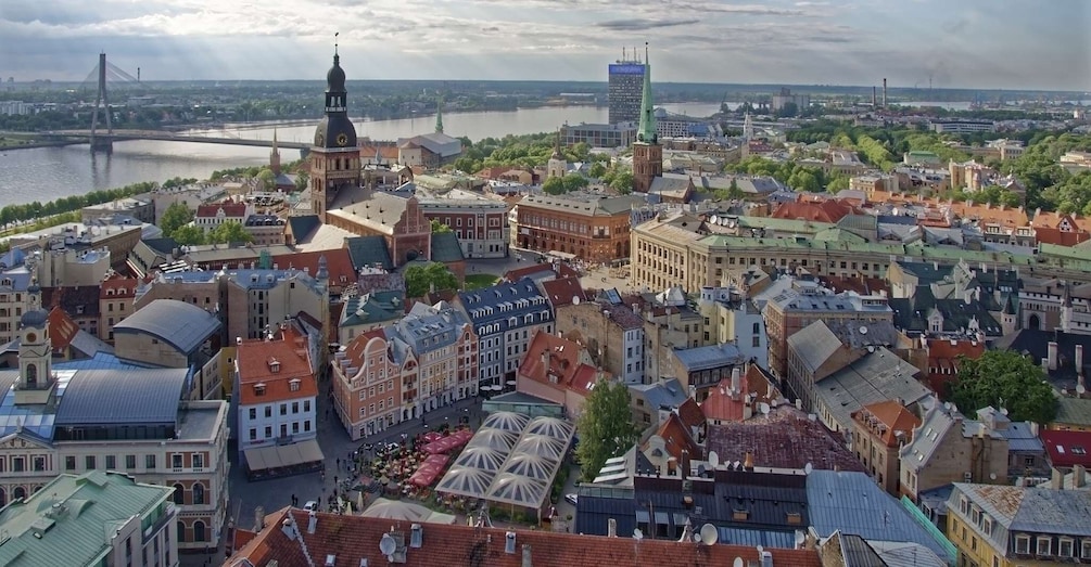 A cityscape with historic buildings, a river, and a bridge in the background. 2