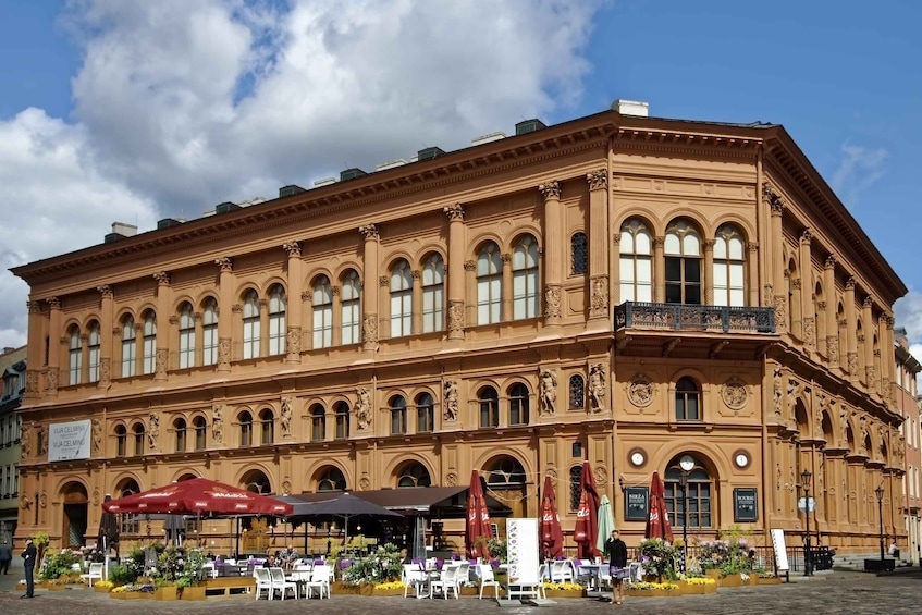 A historic building with ornate architecture, outdoor seating, and flower arrangements. 5