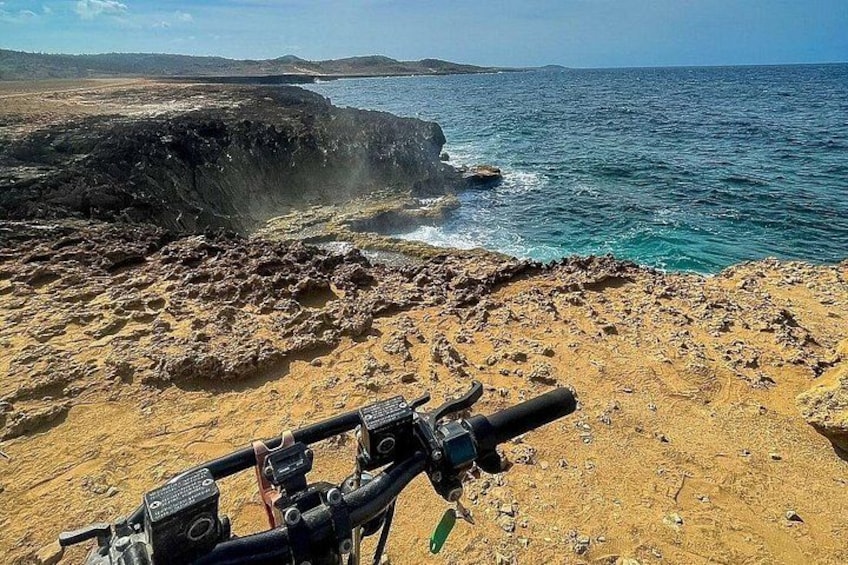 A rocky coastline with a clear view of the ocean and distant land. 2