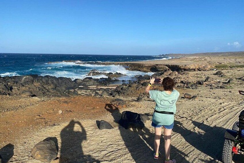 Una persona de pie sobre una playa rocosa, mirando hacia el oc éano. 4