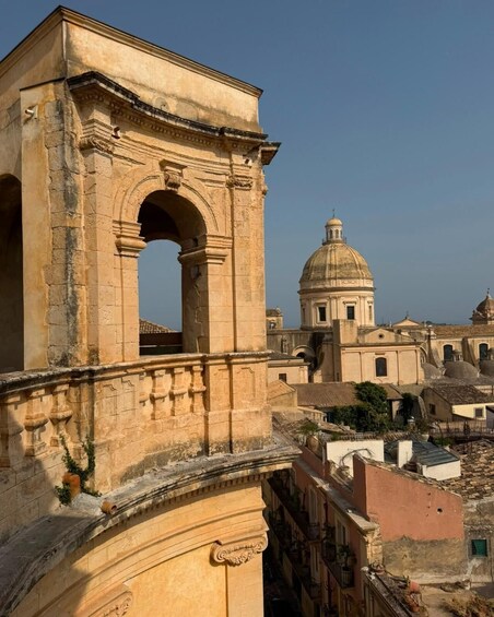 An ancient stone archway with a dome-topped building in the background. 3