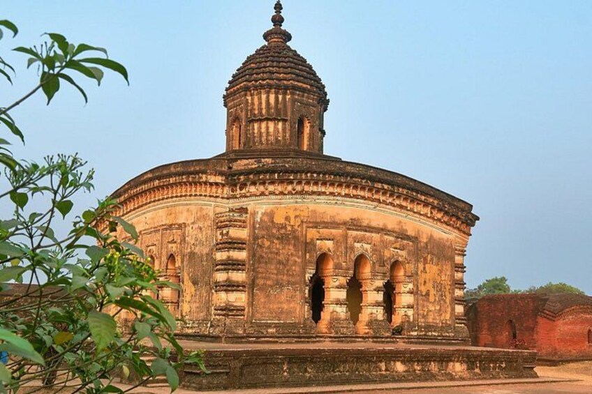 An ancient, circular stone structure with a dome and arched windows. 5