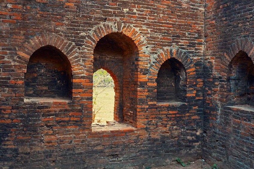 A brick wall with three arched openings. 4