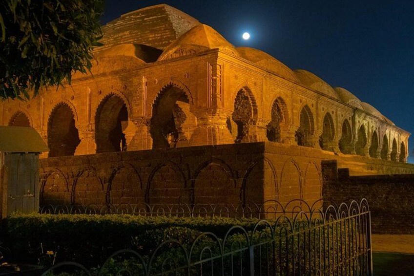 A historic building with arches and domes, illuminated at night. 2