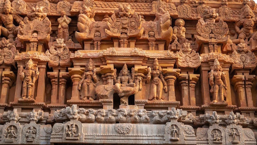 A detailed stone temple facade with intricate carvings of deities, mythological figures, and architectural elements. 5