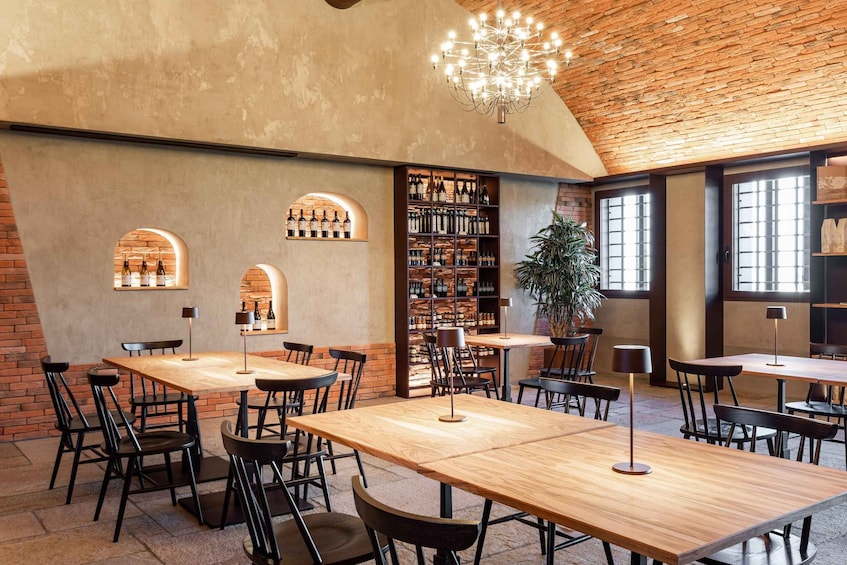 A cozy restaurant with brick walls, wooden tables, and black chairs. 5
