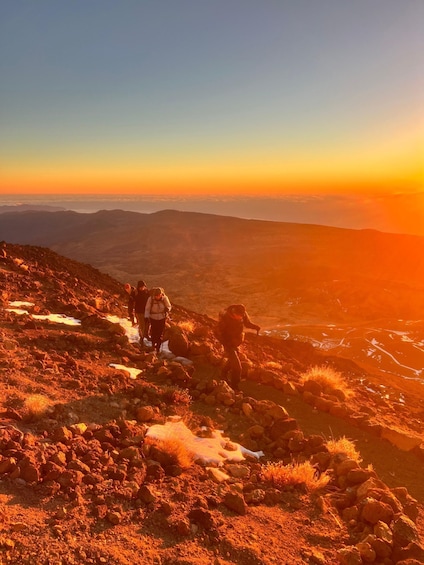 A mountainous landscape with hikers at sunset. 5