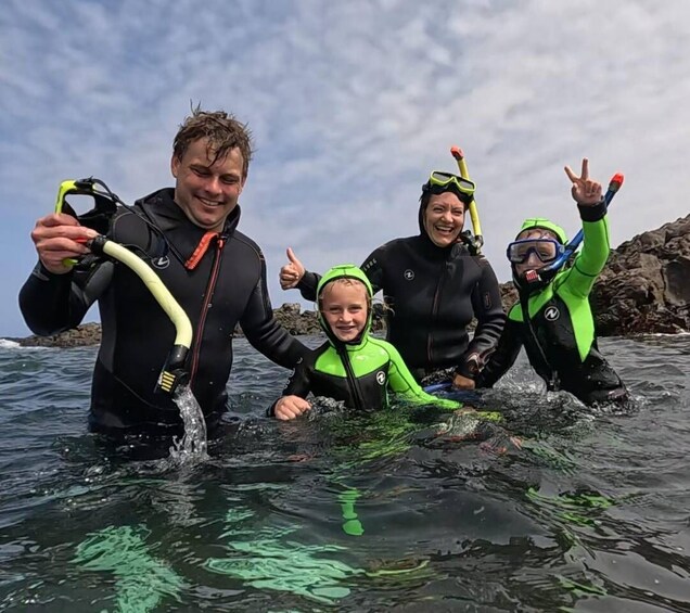 A group of people in wetsuits and snorkels in the water. 5