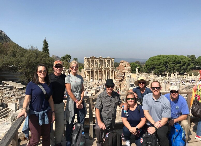A group of tourists at the ancient ruins of Ephesus, with the Temple of Artemis visible in the background. 1